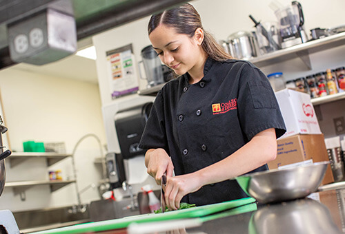 Photo of a culinary arts student preparing food.